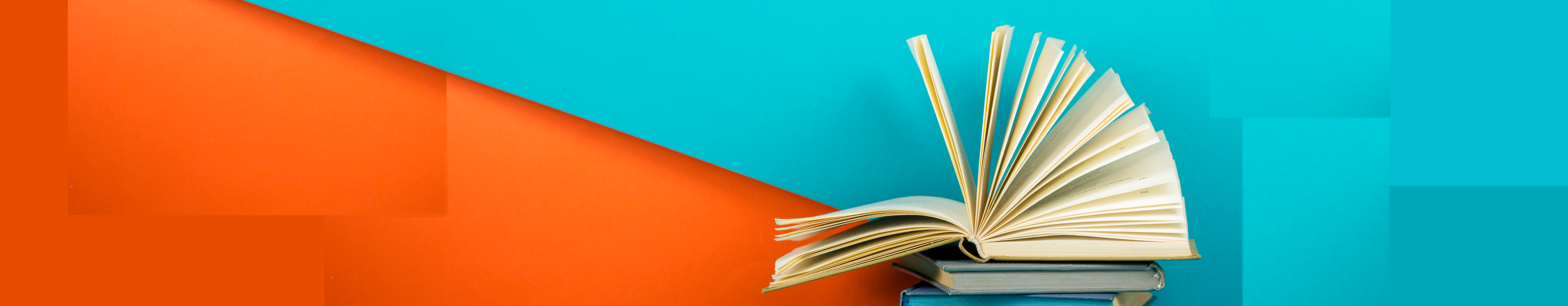 An open book sitting infront of a colorful wall.